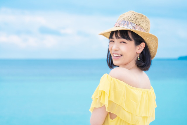 海で帽子をかぶる女性